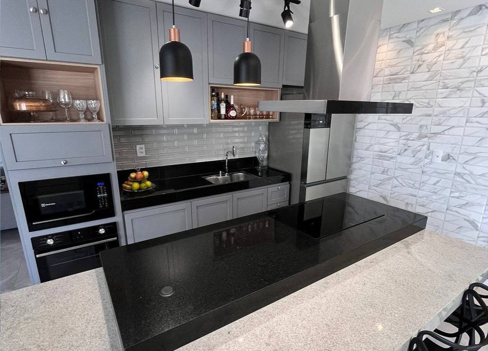 Cozinha com bancada e ilha em granito preto