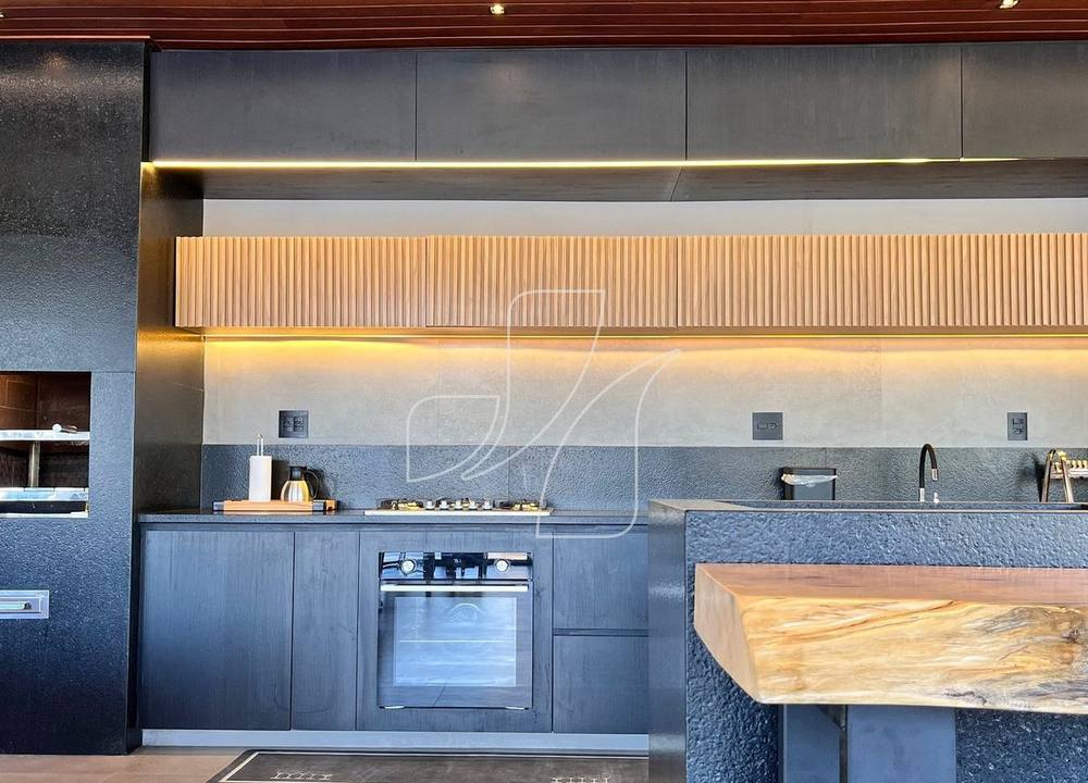 Cozinha integrada com bancada em pedra e iluminação embutida